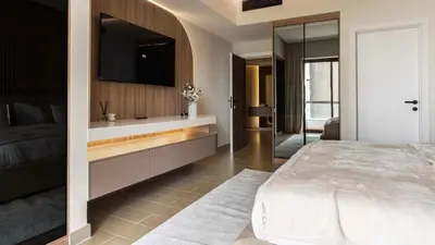a bedroom with a bed and a flat screen tv at Maison Privee - Ultimate Luxury Penthouse with Pool & Marina Views in Dubai