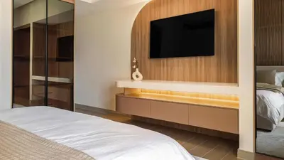 a bedroom with a bed and a tv on a wall at Maison Privee - Ultimate Luxury Penthouse with Pool & Marina Views in Dubai