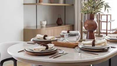 a white table with plates and utensils on it at Maison Privee - Ultimate Luxury Penthouse with Pool & Marina Views in Dubai