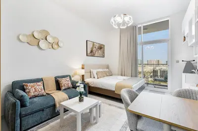 a living room with a couch and a bed at Modern Studio Near Miracle Garden & Dubai Hills in Dubai