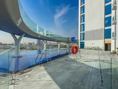 a walkway on top of a building with a pool at Modern Studio Near Miracle Garden & Dubai Hills in Dubai