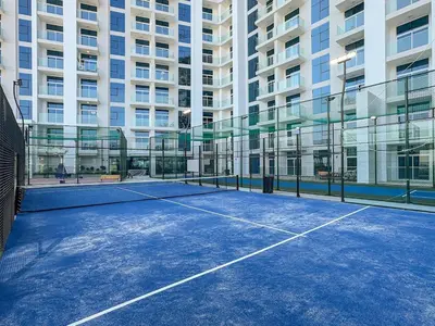 a tennis court in front of a building at Modern Studio Near Miracle Garden & Dubai Hills in Dubai