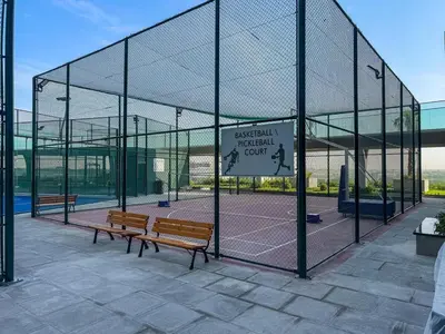 a batting cage with two benches on a tennis court at Modern Studio Near Miracle Garden & Dubai Hills in Dubai