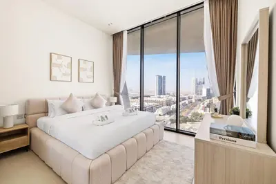 a bedroom with a large white bed and a large window at New Luxury 1BR with Private Pool & Balcony in JVC in Dubai