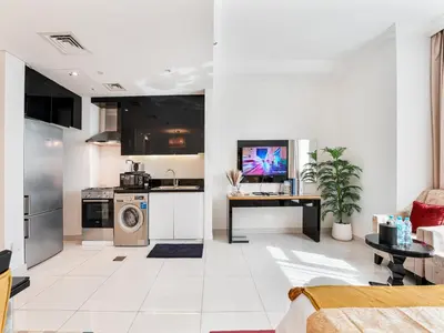 a kitchen and living room with a stove and a washer at Savis Homes - Luxury Studio in Business Bay with Amazing Pool - Capital Bay Tower A in Dubai