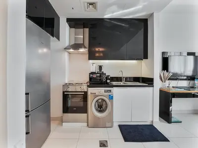 a kitchen with a washing machine and a sink at Savis Homes - Luxury Studio in Business Bay with Amazing Pool - Capital Bay Tower A in Dubai