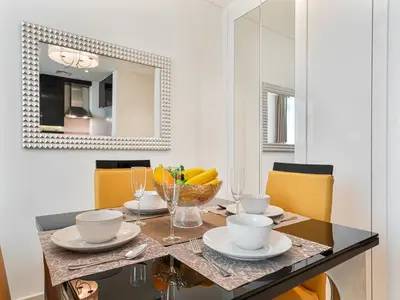 a dining room table with a bowl of fruit and a mirror at Savis Homes - Luxury Studio in Business Bay with Amazing Pool - Capital Bay Tower A in Dubai