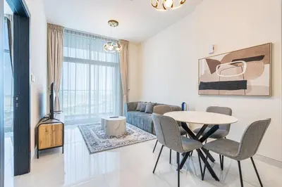 a living room with a table and chairs and a couch at Brand New Home with Amazing Facilities in Dubai