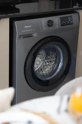 a washing machine with its door open in a kitchen at Stylish 1BR Apartment Near Silicon Mall & Airport in Dubai
