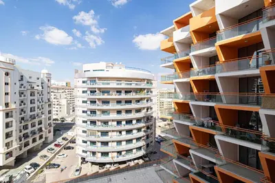an aerial view of a tall apartment building at Stylish 1BR Apartment Near Silicon Mall & Airport in Dubai