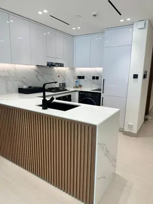 a kitchen with white cabinets and a counter with a sink at Binghatti galaxy in Dubai