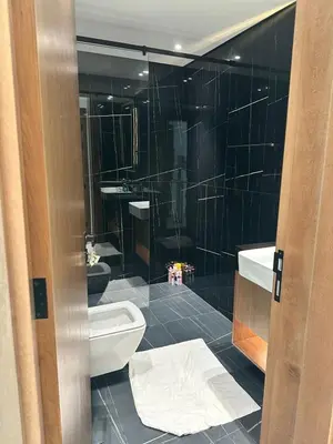 a bathroom with a toilet and a glass shower at Binghatti galaxy in Dubai