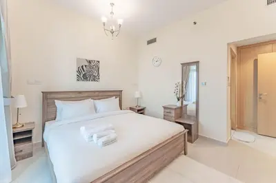 a bedroom with a bed with towels on it at HAVN - 1 bed in May Residence, JVC in Dubai