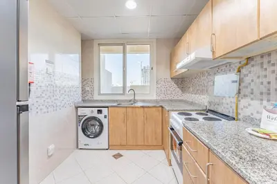 a kitchen with a sink and a washing machine at HAVN - 1 bed in May Residence, JVC in Dubai