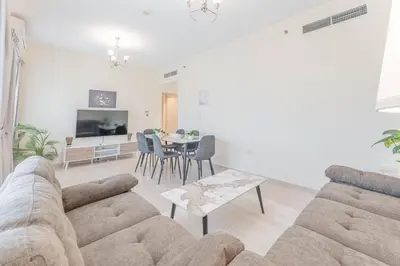 a living room with a couch and a table at HAVN - 1 bed in May Residence, JVC in Dubai