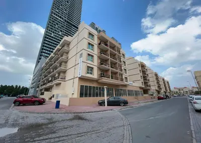 a large apartment building with cars parked in front of it at HAVN - 1 bed in May Residence, JVC in Dubai