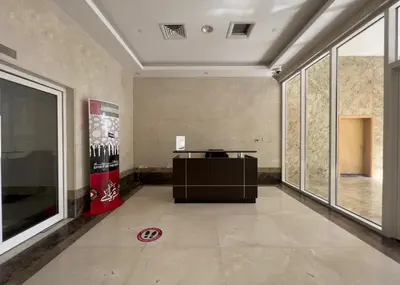 an empty room with a desk in a room with windows at HAVN - 1 bed in May Residence, JVC in Dubai