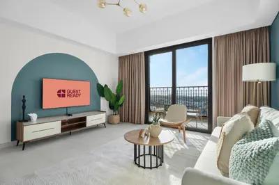 a living room with a couch and a tv at GuestReady - 1 BHK | Serene 9th-Floor Escape in Dubai