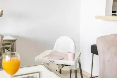 a white chair with a table and a glass of orange juice at JBR Al Bateen Residences By Luxe Living Collection - Private Beach and Sea Views in Dubai