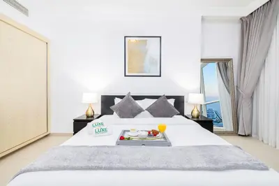 a bedroom with a bed with a tray of food on it at JBR Al Bateen Residences By Luxe Living Collection - Private Beach and Sea Views in Dubai