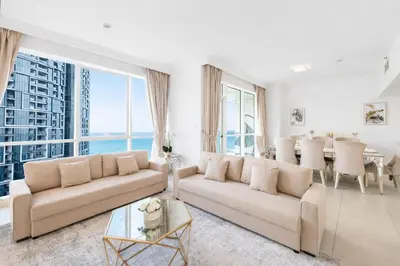 a living room with a large couch and a table at JBR Al Bateen Residences By Luxe Living Collection - Private Beach and Sea Views in Dubai