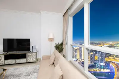 a living room with a couch and a large window at JBR Al Bateen Residences By Luxe Living Collection - Private Beach and Sea Views in Dubai