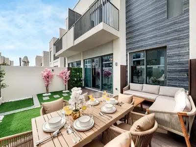 an outdoor patio with a wooden table and chairs at 4BR Villa in Resort-Style Gated Community with Lazy River in Arabian Ranches 3 in Dubai