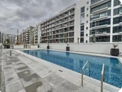 a large swimming pool in front of a building at Luxury Studio big Balcony in Dubai