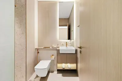 a bathroom with a white toilet and a sink at New 1BR Urban Oasis with Pools & City Views in JVC in Dubai