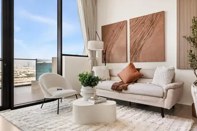 a living room with a couch and a chair at New 1BR Urban Oasis with Pools & City Views in JVC in Dubai