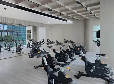 a gym with a bunch of exercise bikes at New 1BR Urban Oasis with Pools & City Views in JVC in Dubai