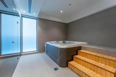 a bathroom with a large tub and a window at Brand New 1BDR with Pool, Jacuzzi, Sauna, Gym in Dubai