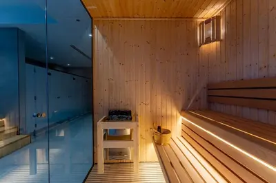 a sauna with a bench in a wooden wall at Brand New 1BDR with Pool, Jacuzzi, Sauna, Gym in Dubai