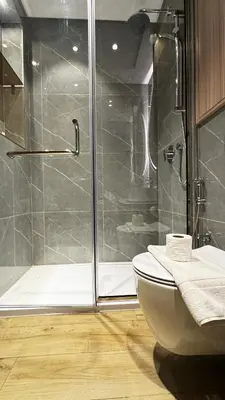 a bathroom with a glass shower and a toilet at Brand New 1BDR with Pool, Jacuzzi, Sauna, Gym in Dubai