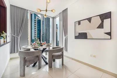 a dining room with a table and chairs and windows at Stunning Burj & Fountain View Downtown 29 Blvd in Dubai