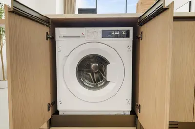 a washer and dryer in a wooden box at New Chic 1BR Apt with Private Pool & City View in JVC in Dubai
