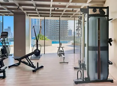a gym with treadmills and exercise equipment in a building at New Chic 1BR Apt with Private Pool & City View in JVC in Dubai