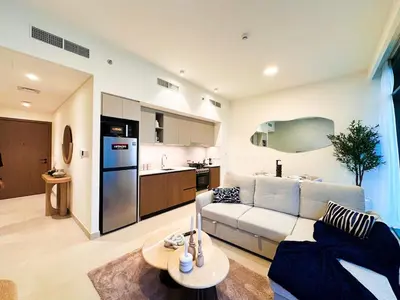a living room with a couch and a kitchen at 1-Bedroom Apartment - Burj Khalifa -Water View in Dubai