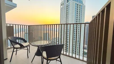 a balcony with chairs and a table and a view of a city at 1-Bedroom Apartment - Burj Khalifa -Water View in Dubai