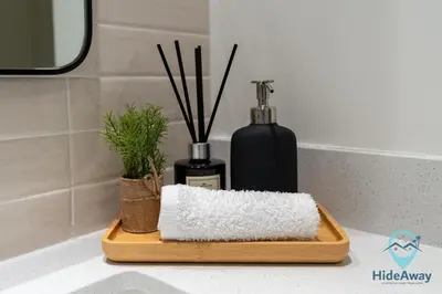 a bathroom counter with a cutting board and a bottle of soap at Stunning 1BR l Creek Crescent Suite in Dubai