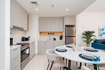 a kitchen and dining room with a table and chairs at Stunning 1BR l Creek Crescent Suite in Dubai