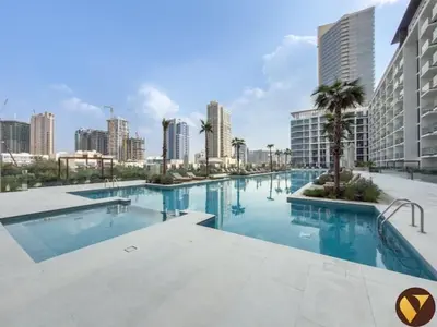 a large swimming pool in a city with tall buildings at Vogue JVC Binghatti Phoenix near Circle Mall, Studio Apartment with Balcony and Access to all Amenities in Dubai