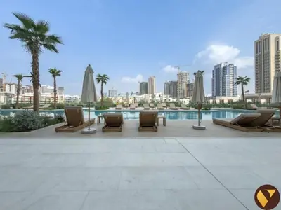 a patio with lounge chairs and a pool and a city at Vogue JVC Binghatti Phoenix near Circle Mall, Studio Apartment with Balcony and Access to all Amenities in Dubai