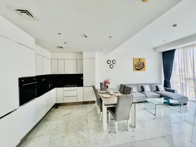 a kitchen and living room with a table and a couch at Luxury 1BR near Burj Khalifa Business Bay Free Parking in Dubai