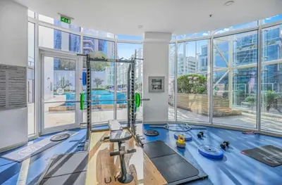 an indoor gym with a fitness room with a pool at Luxury 1BR near Burj Khalifa Business Bay Free Parking in Dubai