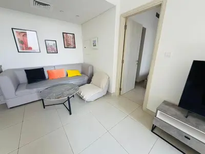 a living room with a couch and a table at 1BR, Afnan 2, Midtown, Dubai Production City in Dubai