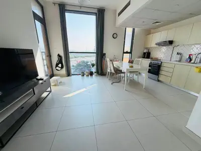 a large kitchen with a large white tiled floor at 1BR, Afnan 2, Midtown, Dubai Production City in Dubai