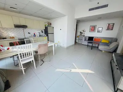 a large kitchen and living room with a table and chairs at 1BR, Afnan 2, Midtown, Dubai Production City in Dubai