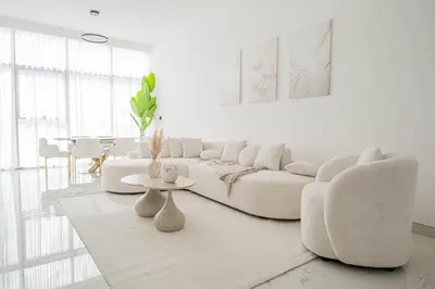 a white living room with a white couch and a table at Stunning Burj Khalifa View Luxury 2BR Business Bay in Dubai