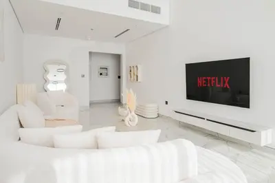 a living room with white furniture and a flat screen tv at Stunning Burj Khalifa View Luxury 2BR Business Bay in Dubai